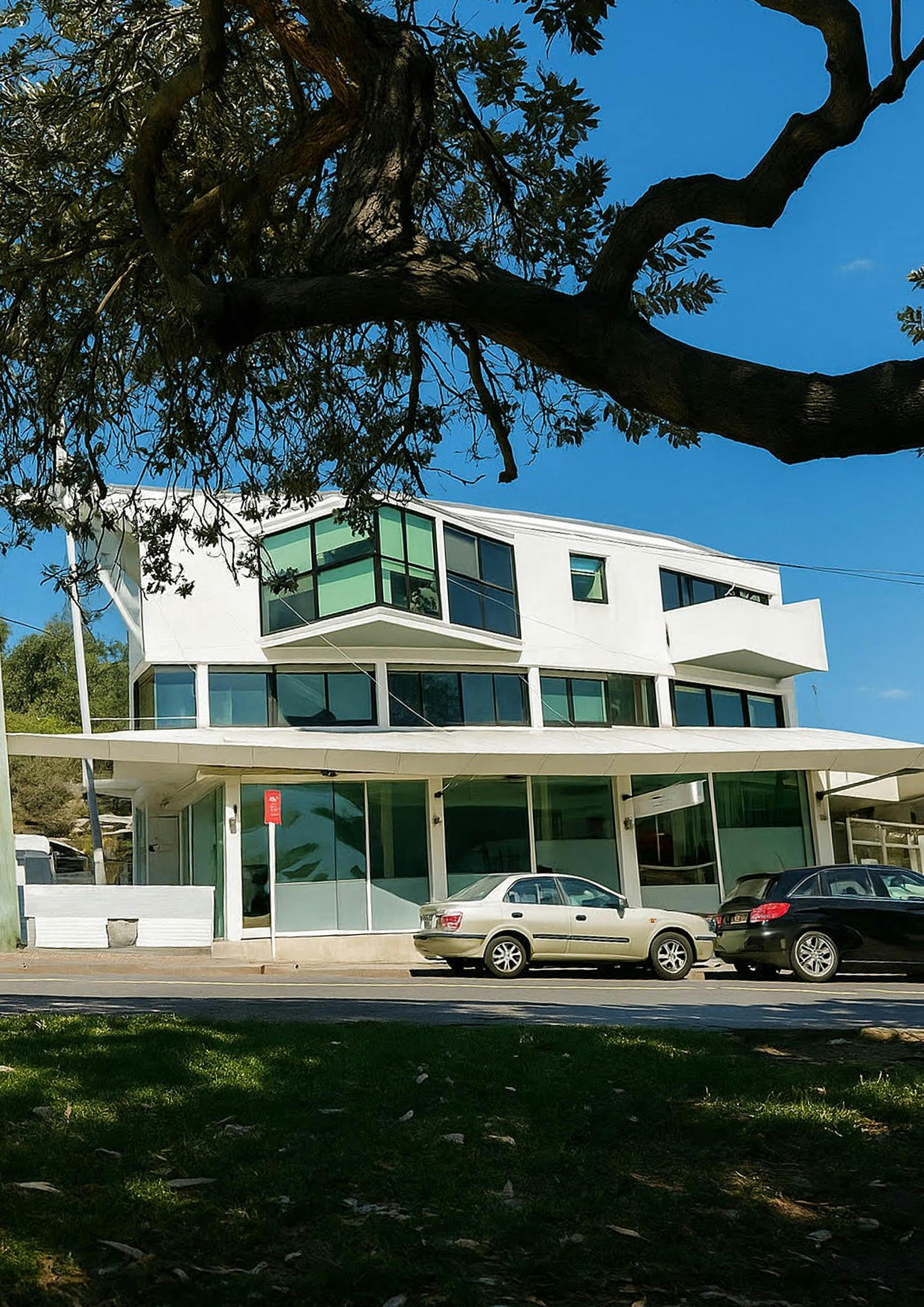 Front exterior of Esteria Café with outdoor trees and street view in Watsons Bay