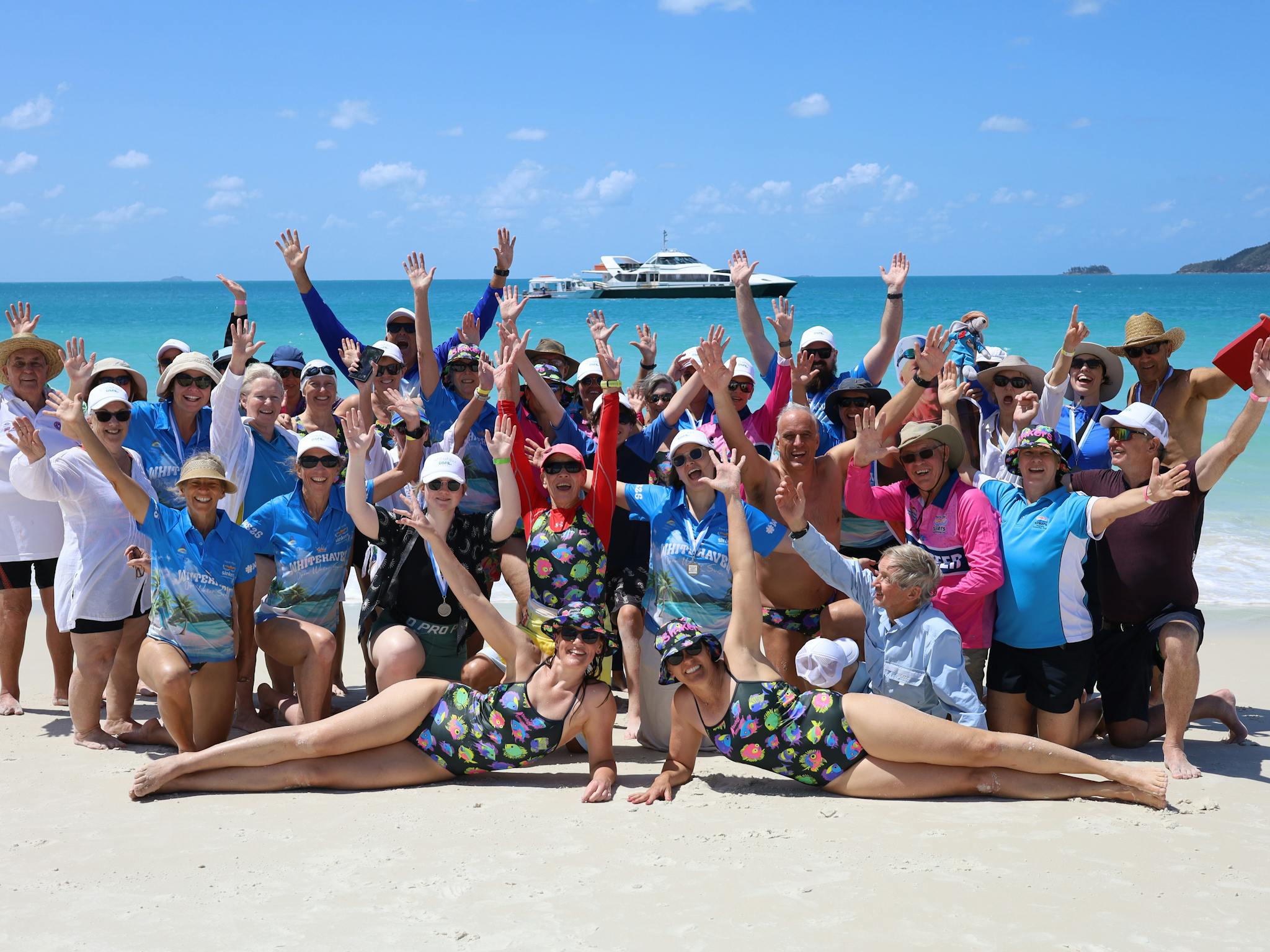 group photo on Whitehaven beach post swimming event with hands in the air celebrating group photo on Whitehaven beach post swimming event with hands in the air celebrating