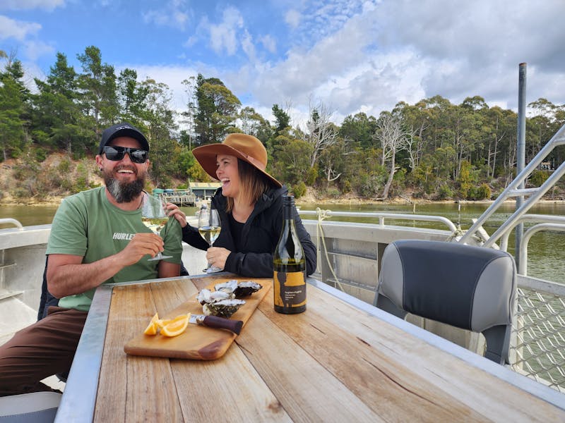 Guests are seated with freshly shucked oysters aboard the Tunacorn toasting local wine