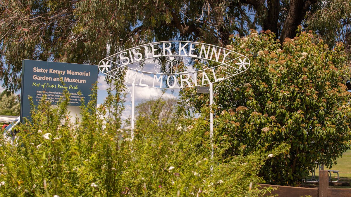 Close of view of white metal sign stating Sister Kenny Memorial.