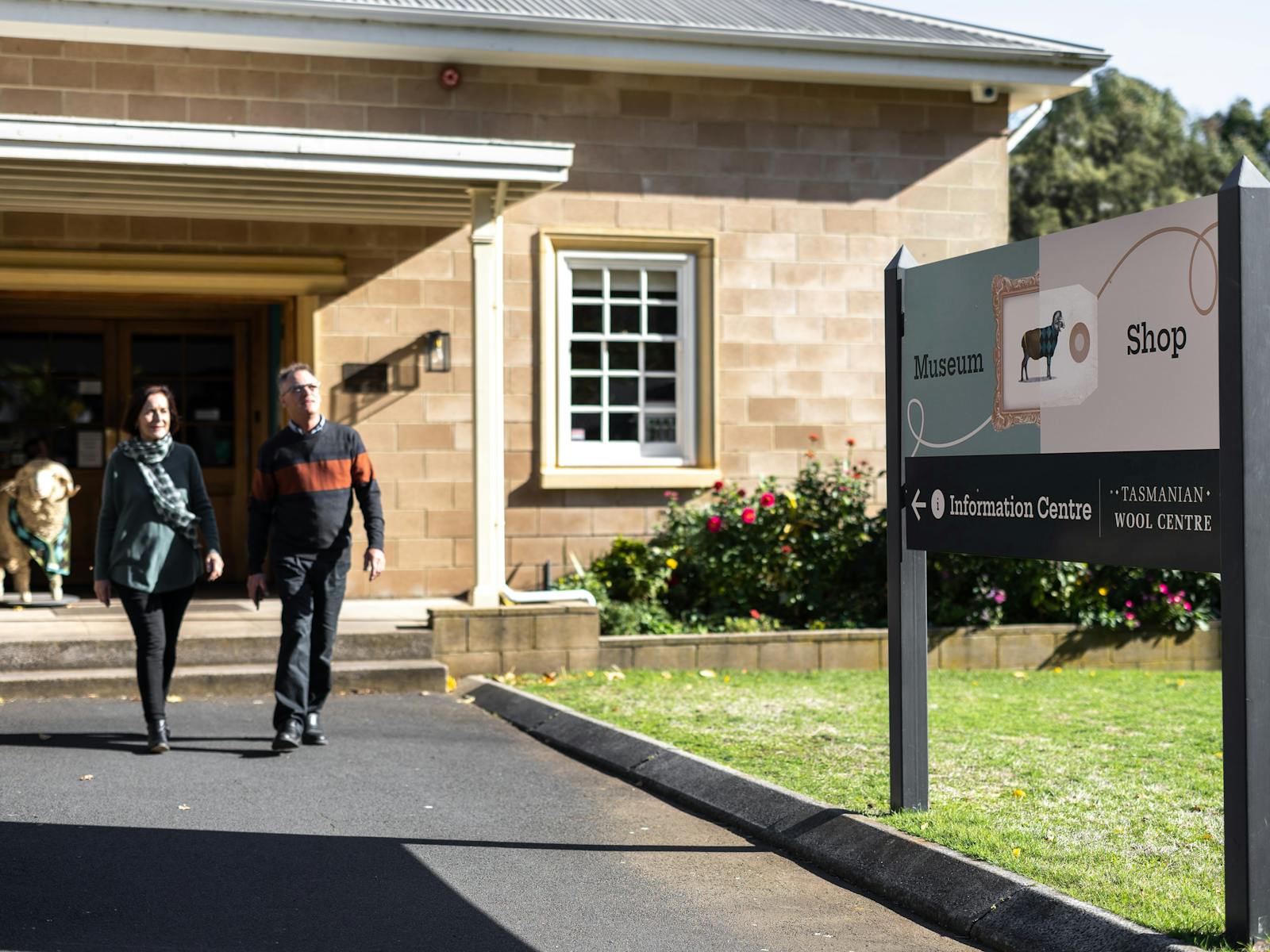 Man and women exiting the front of the Tasmanian Wool Centre in Ross