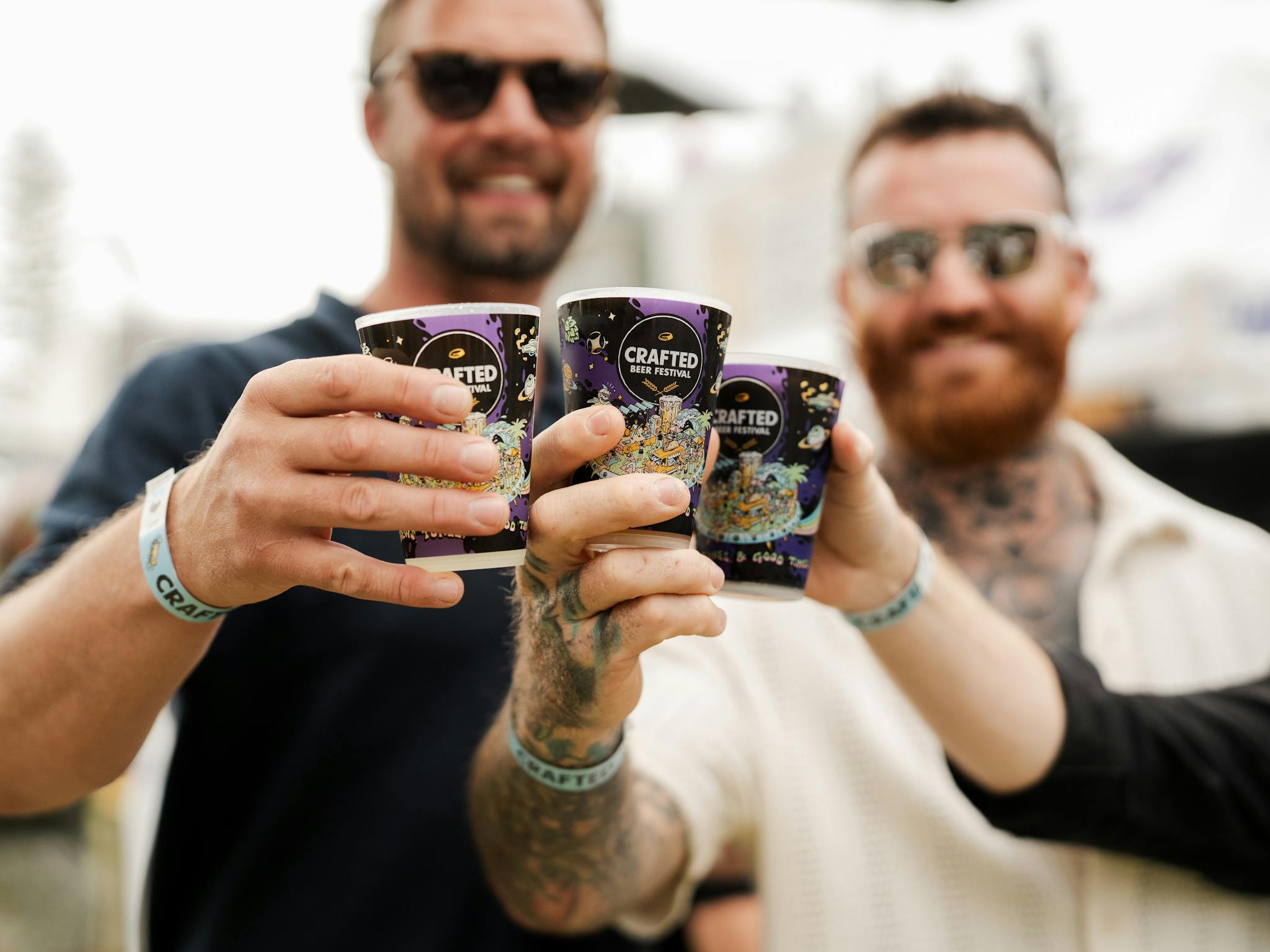 A small group of men cheersing beers at Crafted Festival A small group of men cheersing beers at Crafted Festival