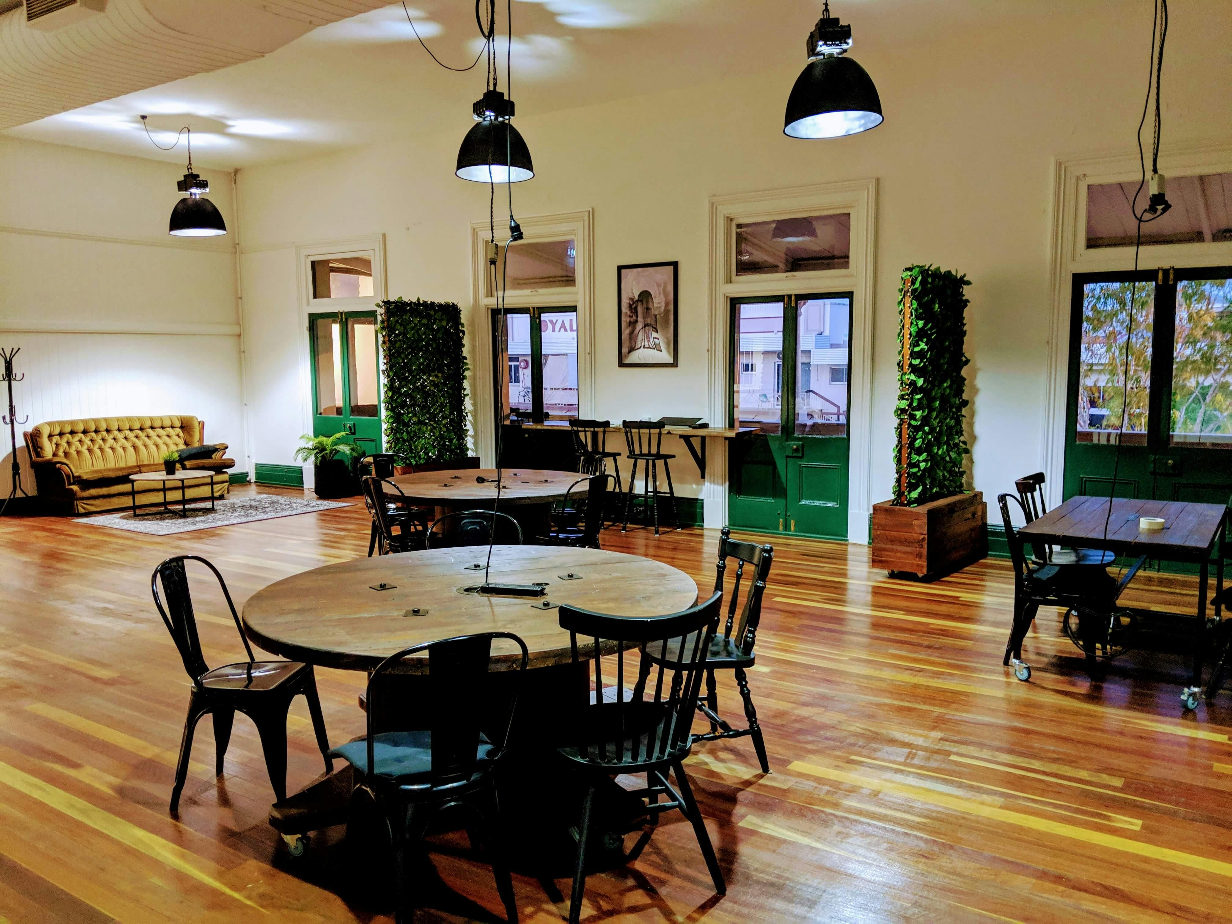 This is a photo of a room containing tables and chairs that can be hired in the coworking area
