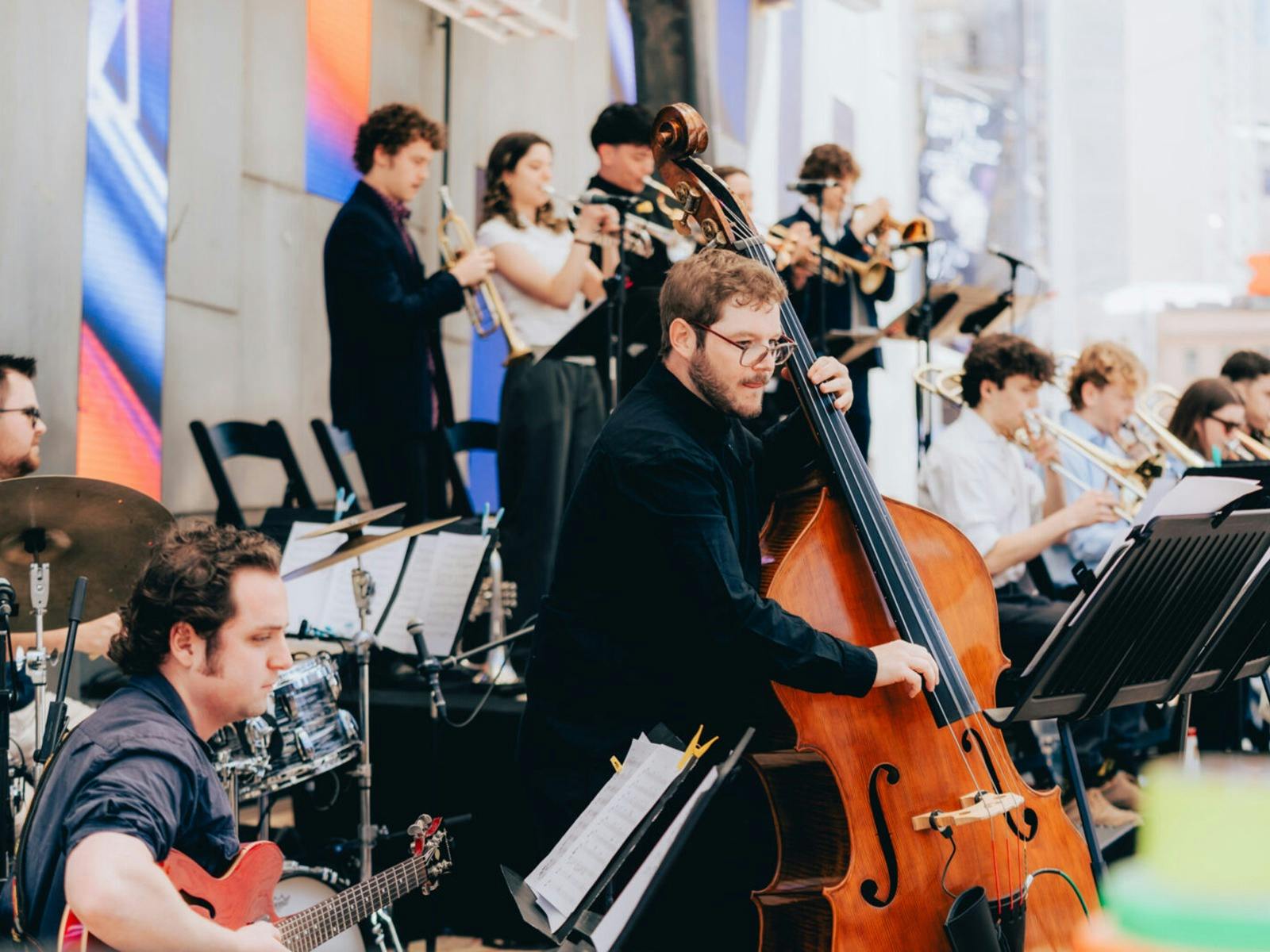 A group of jazz musicians playing instruments with a double bass player in the foreground