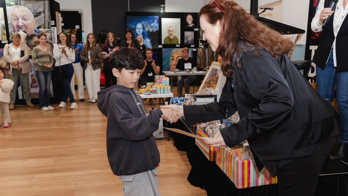 Event director hands junior artist certificate