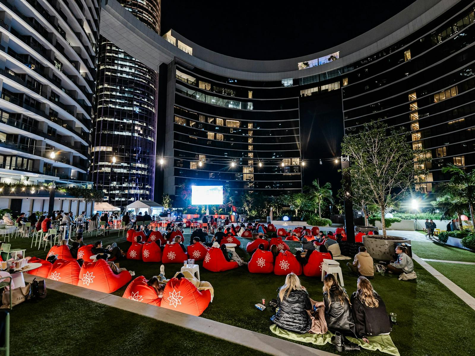 People at an outdoor cinema behind Queen's Wharf People at an outdoor cinema behind Queen's Wharf
