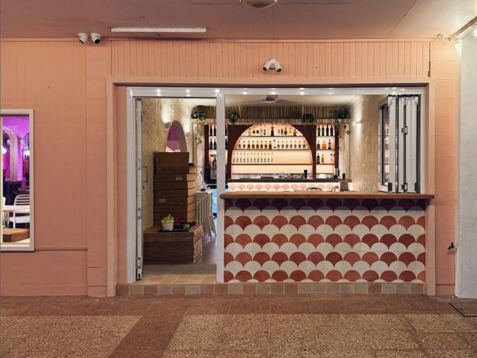 Mosaic tile shop front with bar in background
