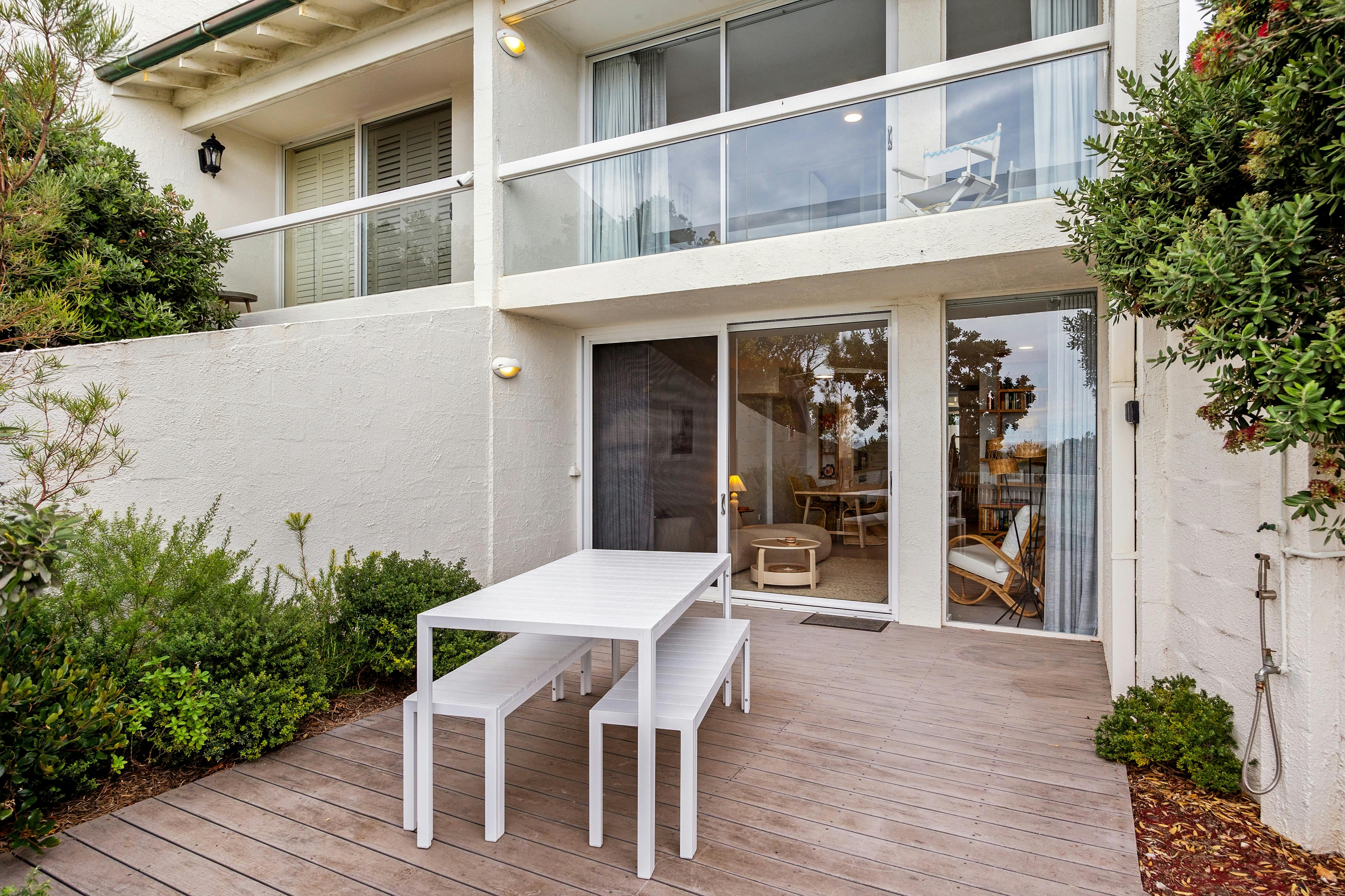 Private beachfront courtyard with outdoor dining and shower