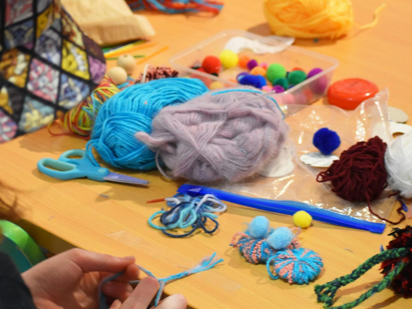 Kids making art with pom poms and pipe cleaners
