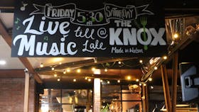 Chalk board sign advertising live music on Friday and Saturday