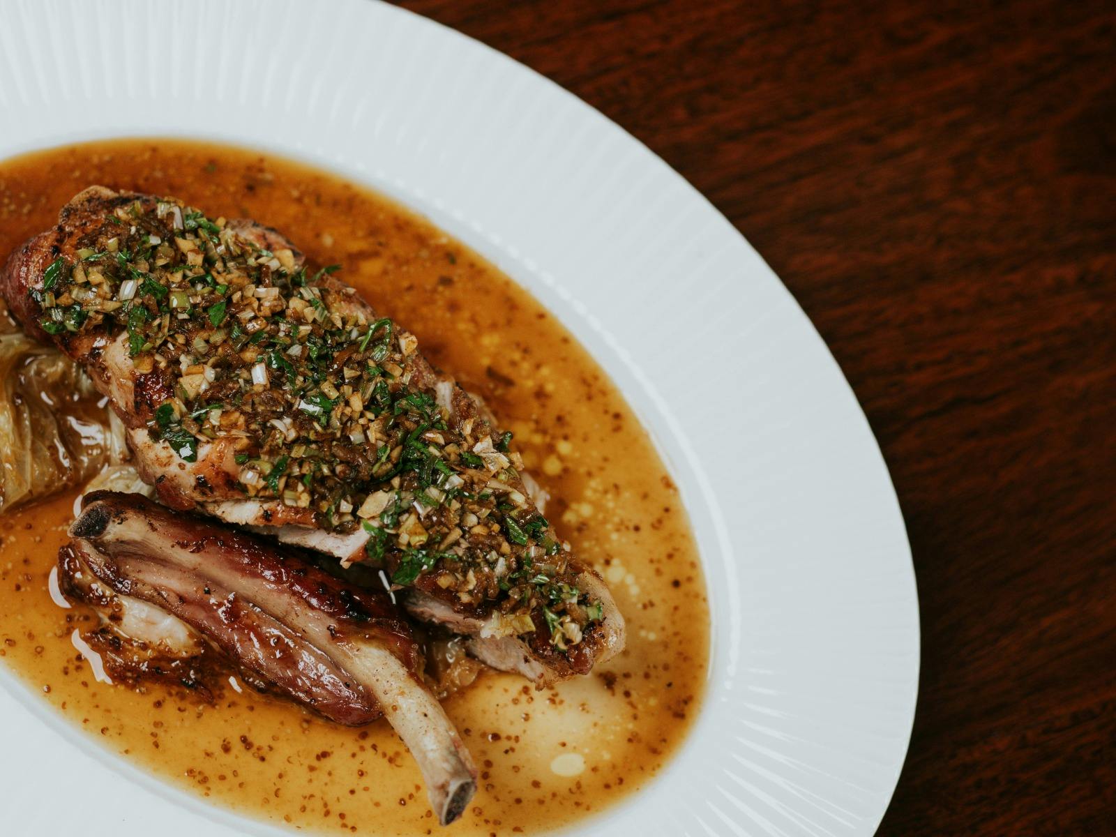 Roast pork chop, spring onion and garlic relish, sour cabbage, mustard jus from the seasonal menu