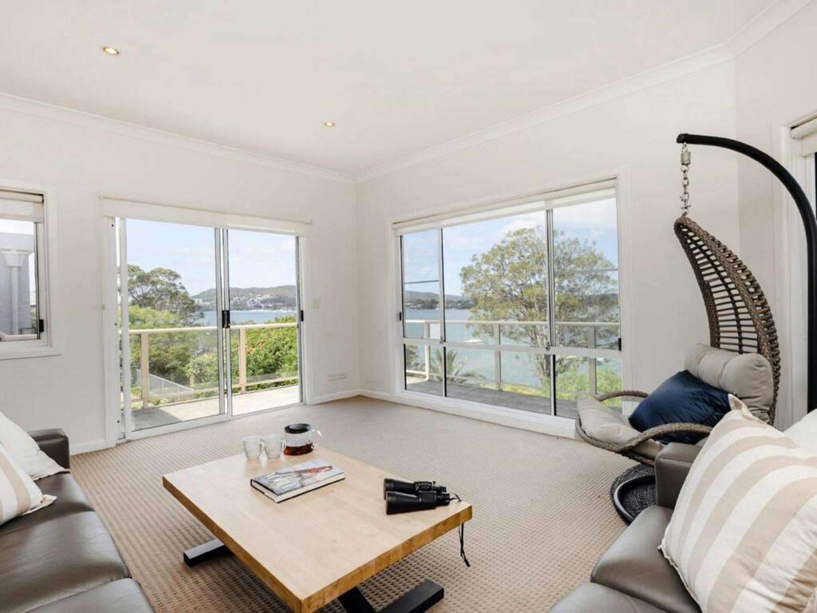 Light-filled lounge area with comfortable sofa, coffee table and picturesque water views.