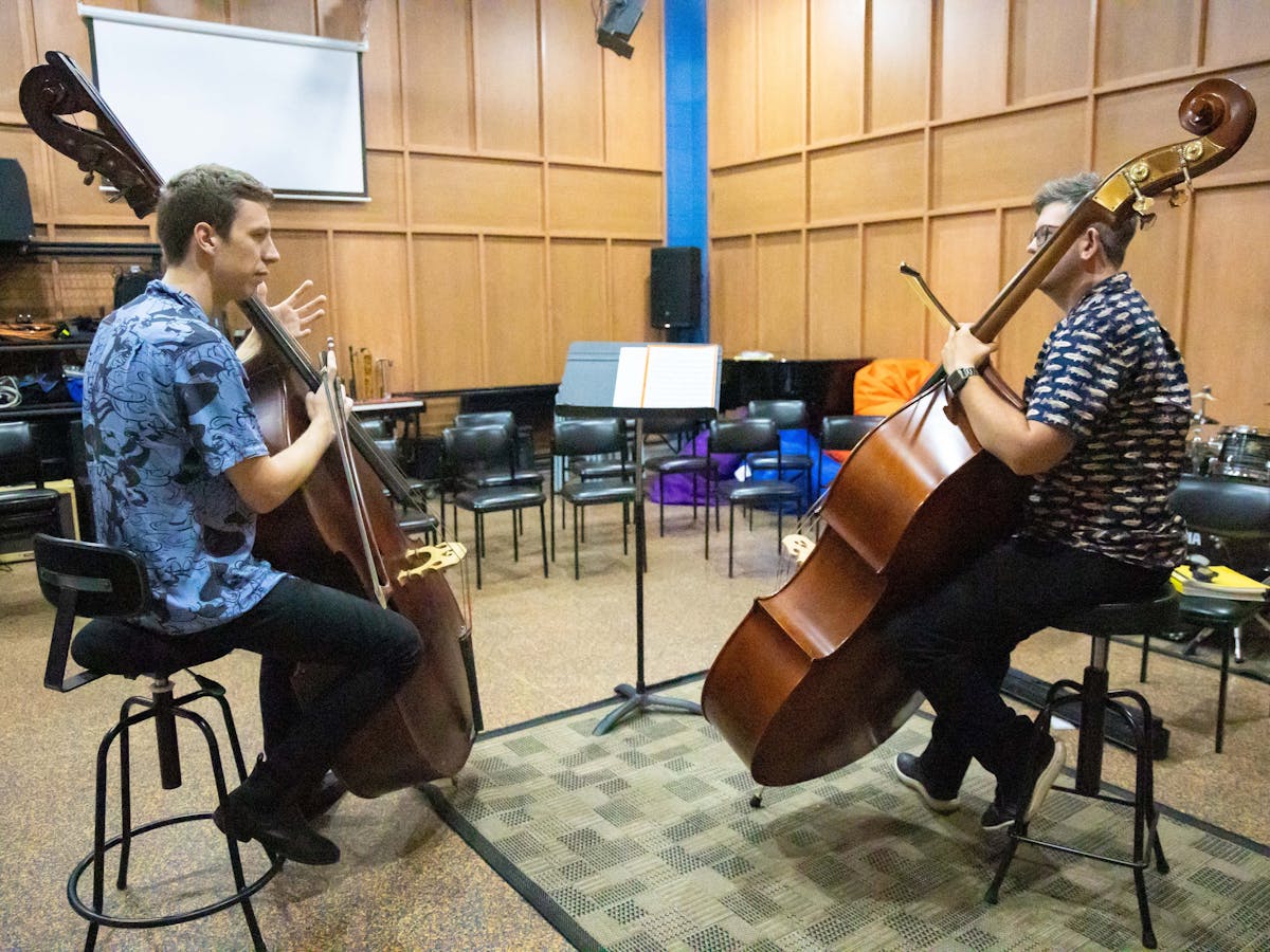 A double bassist receiving a coaching session with a professional double bassist