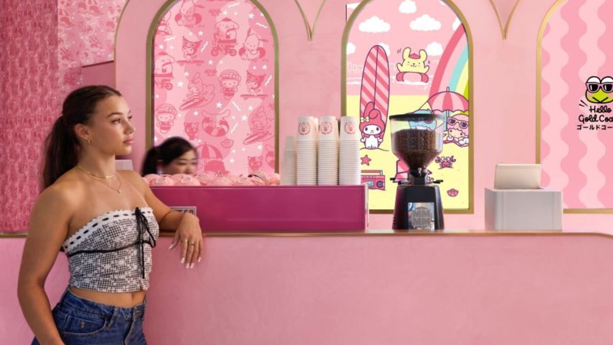 A cafe area with pink seating and a wall featuring colorful Sanrio character art.