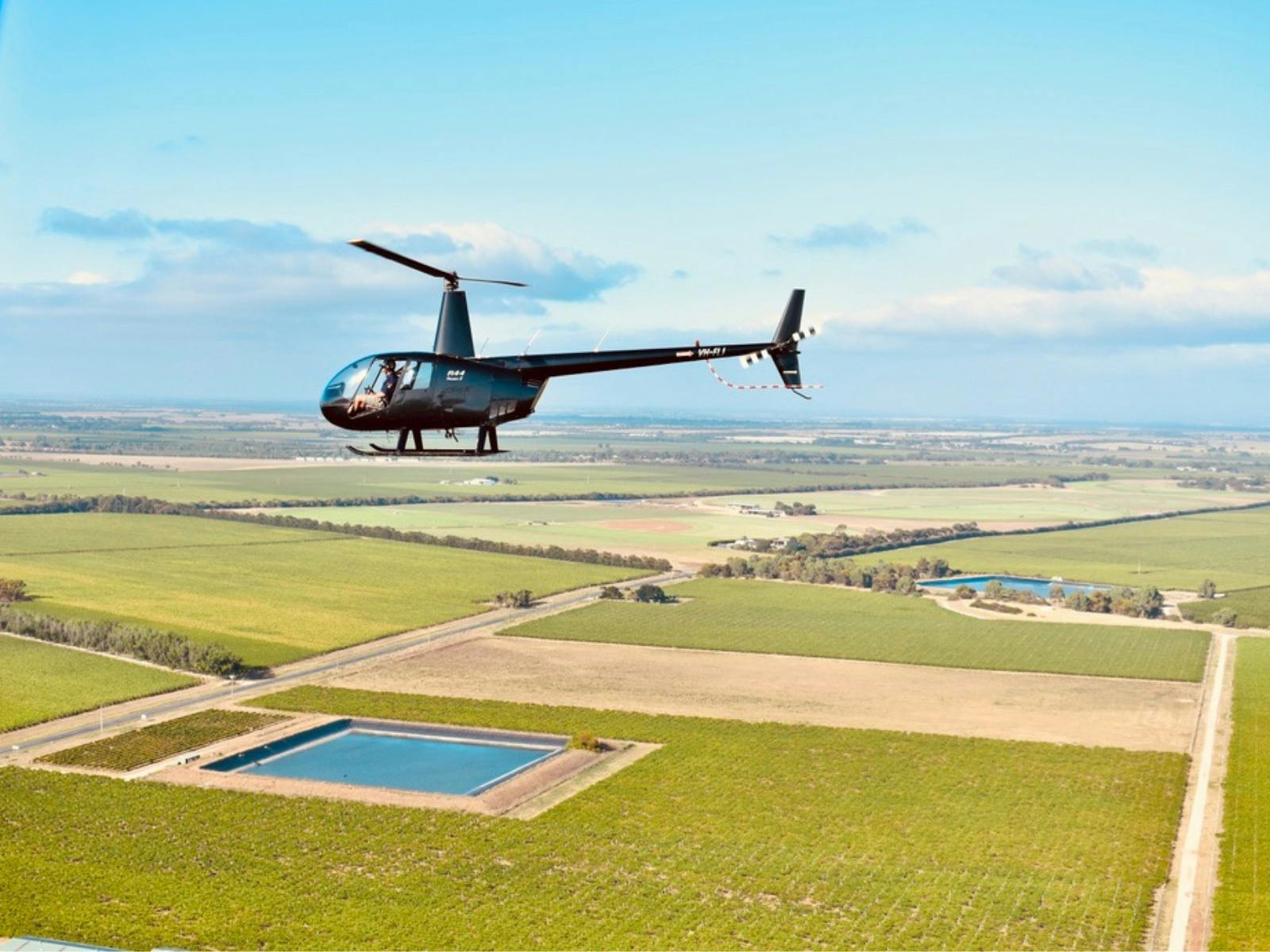 South Australian Helicopters in the sky above beautiful scenery.