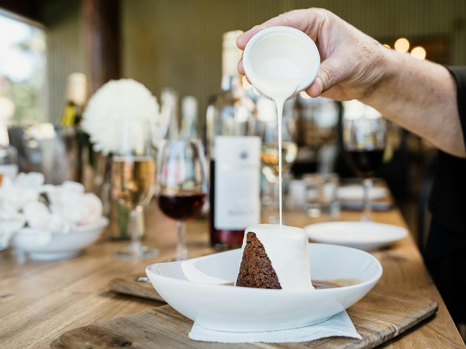 Pouring cream onto our signature dessert, sticky muscat pudding with muscat sauce.