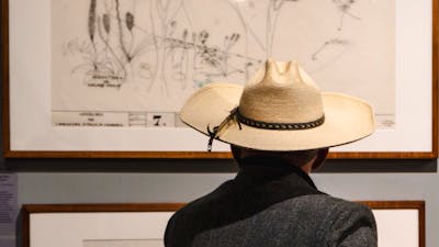 Man looking at architectural sketches in the Taglietti exhibition