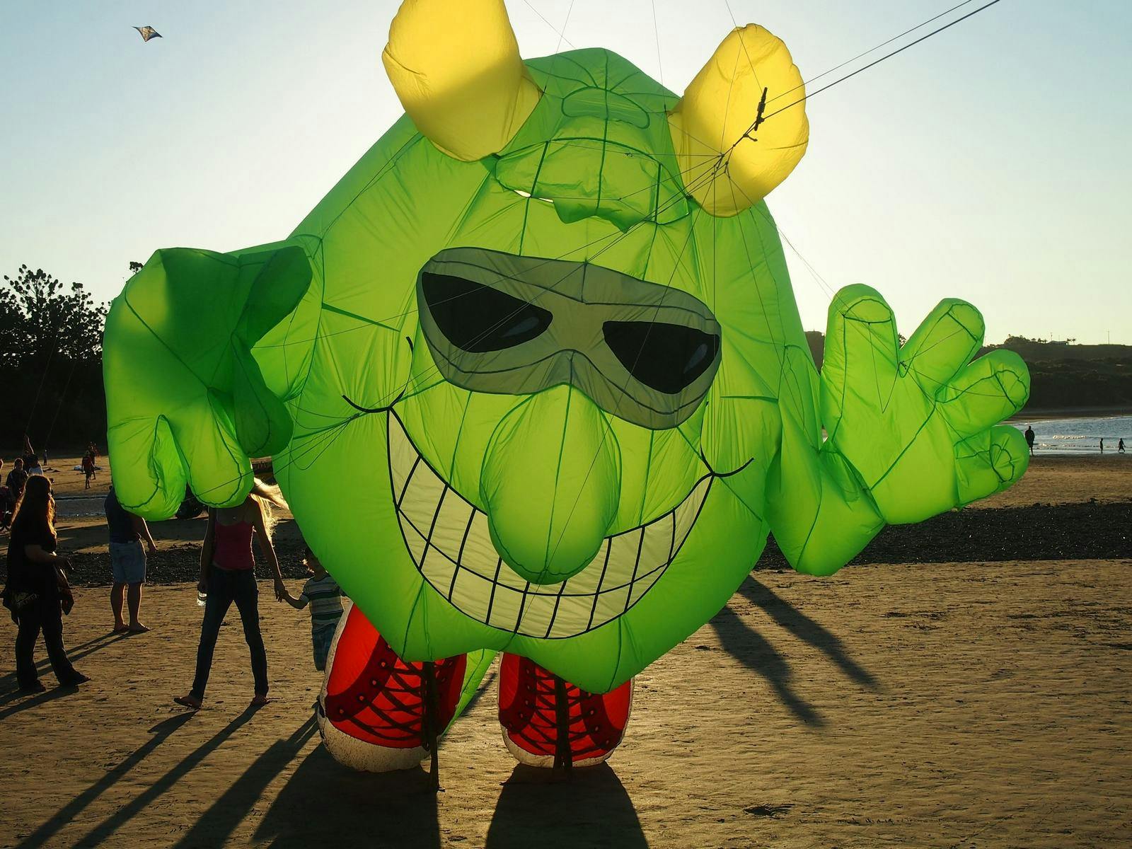 Large green inflatable with yellow horns and red shoes