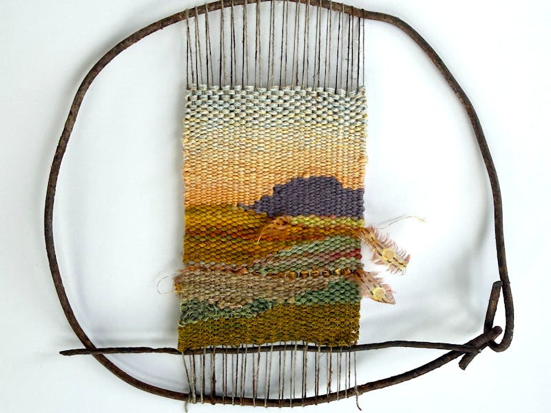 a woven outback landscape, held within a circular frame
