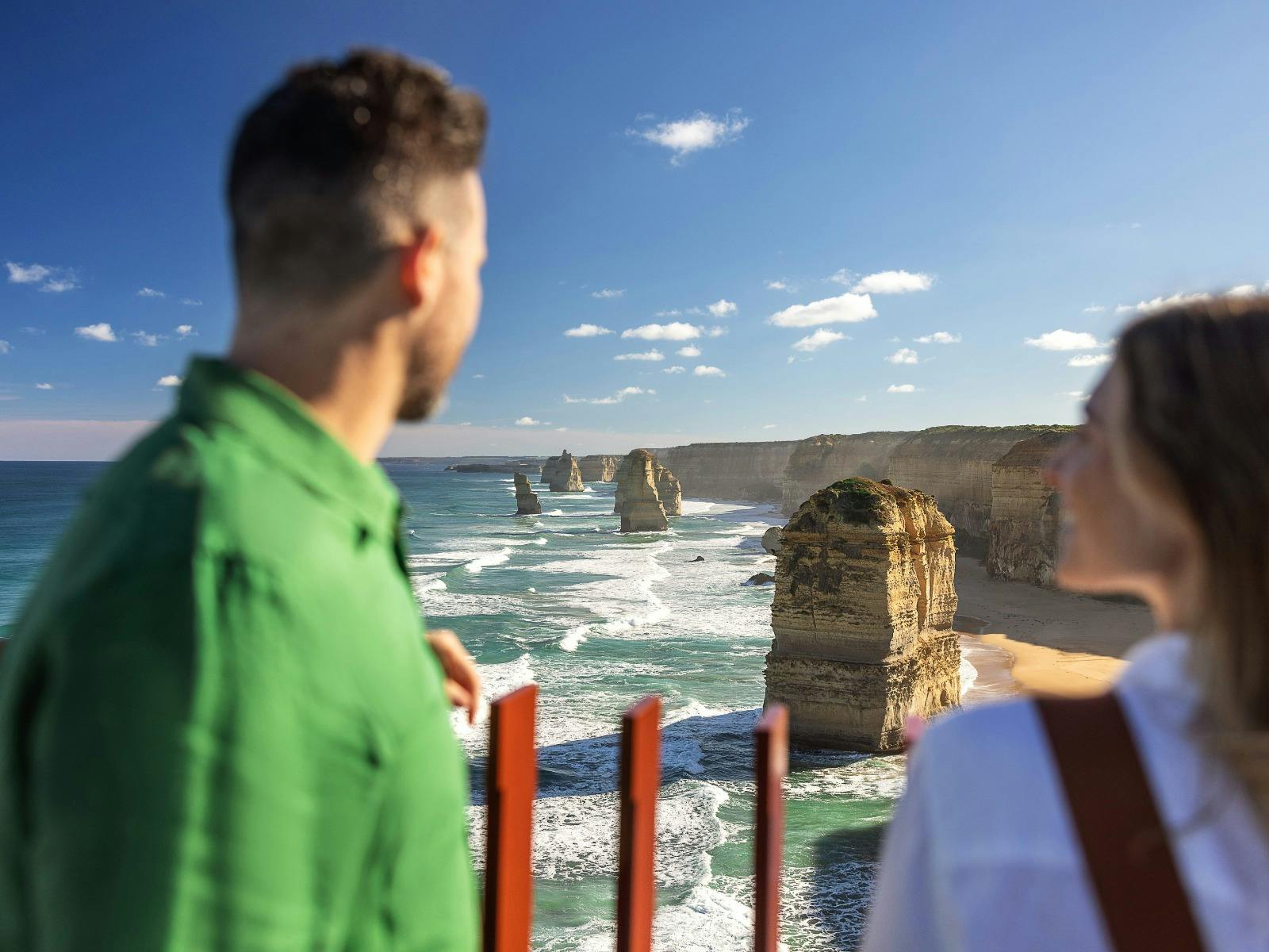 A couple look out over the 12 apostles rock formation located in the ocean