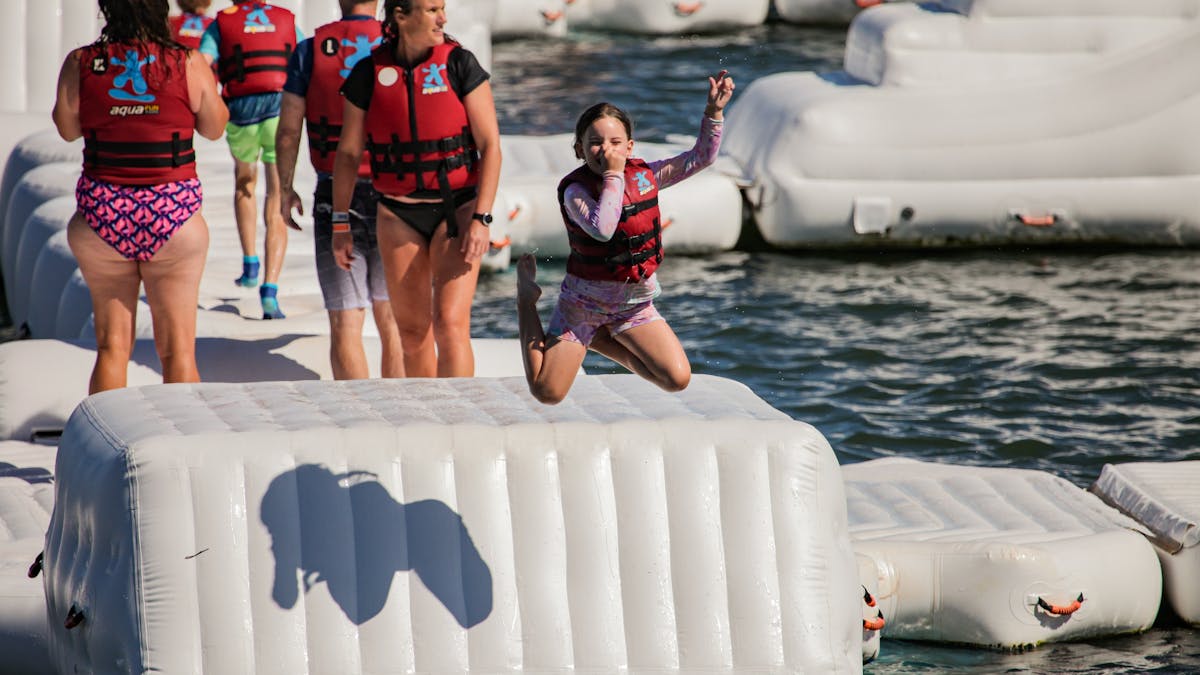 Person jumping off box into water