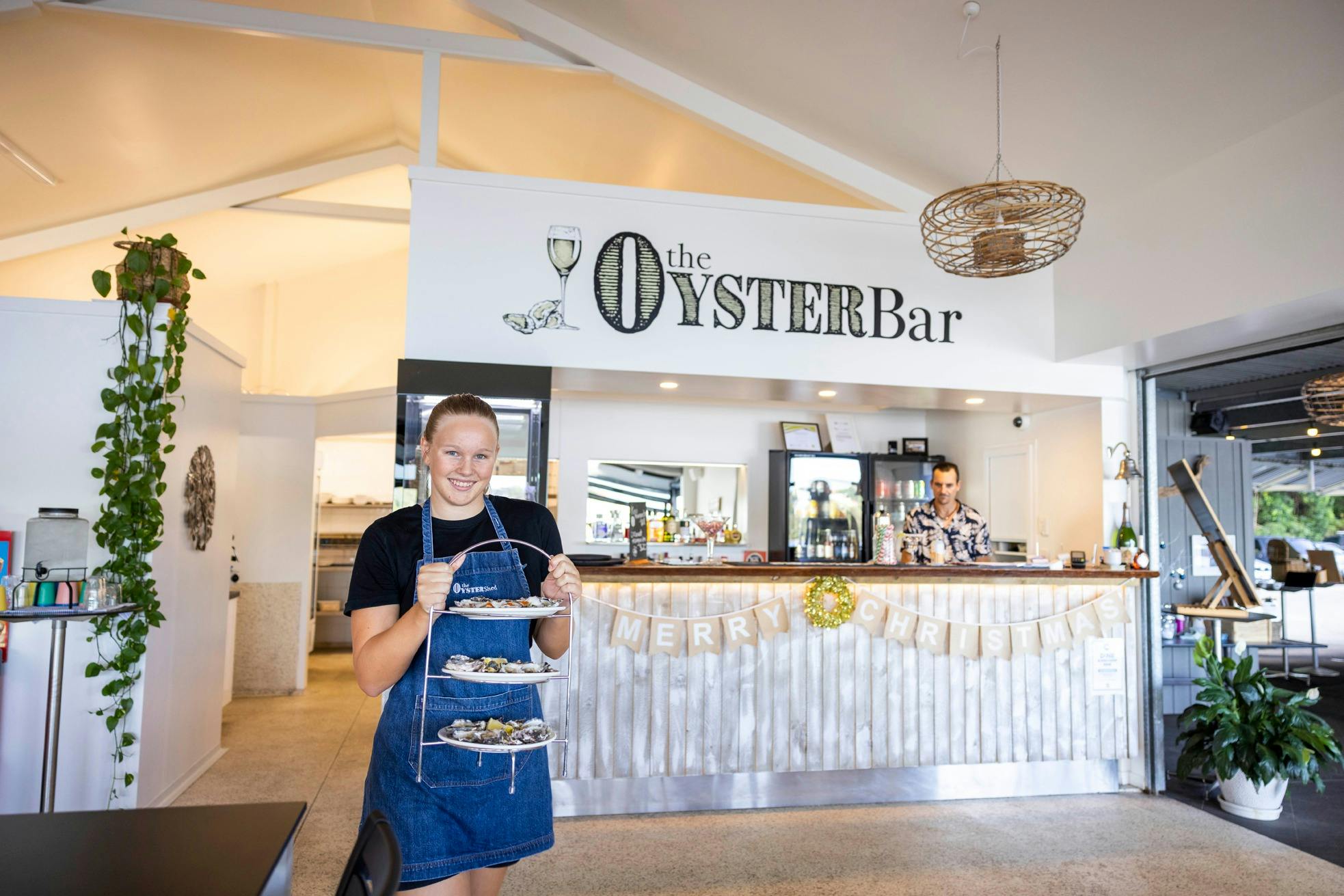 Waitress emerges from The Oyster Shed kitchen with  a with a triple stack of delicious fresh oysters