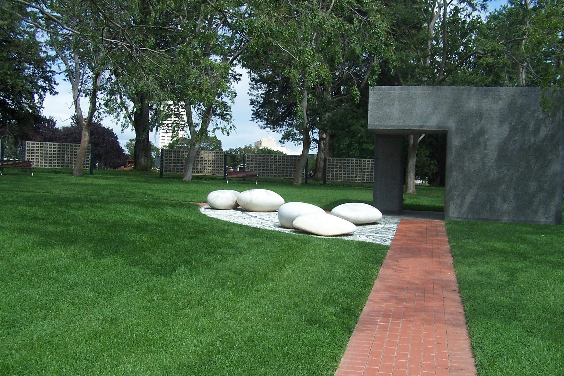 Paved path with mown lawn and ornamental large smooth white stones