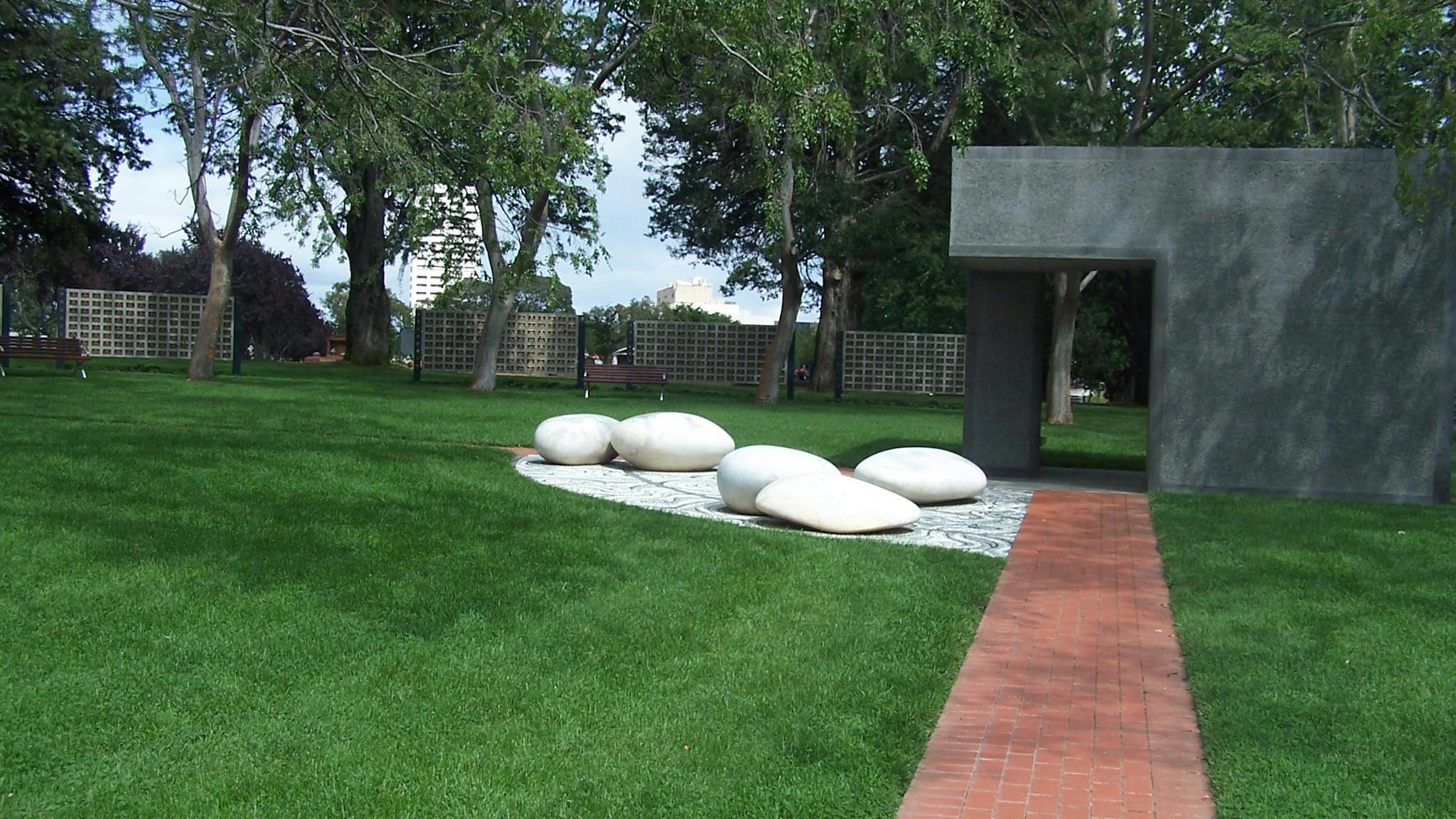 Paved path with mown lawn and ornamental large smooth white stones