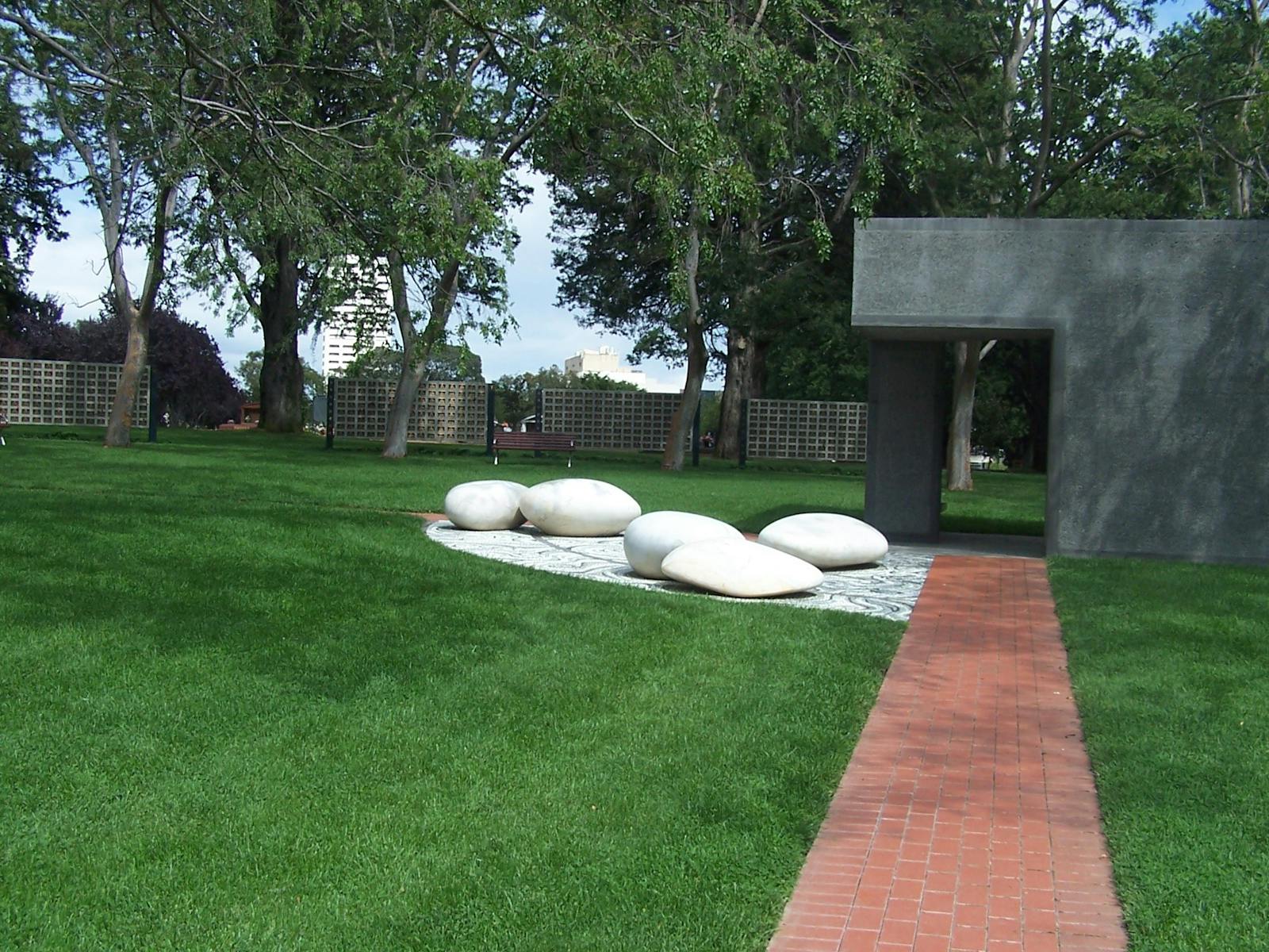 Paved path with mown lawn and ornamental large smooth white stones