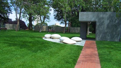 Paved path with mown lawn and ornamental large smooth white stones