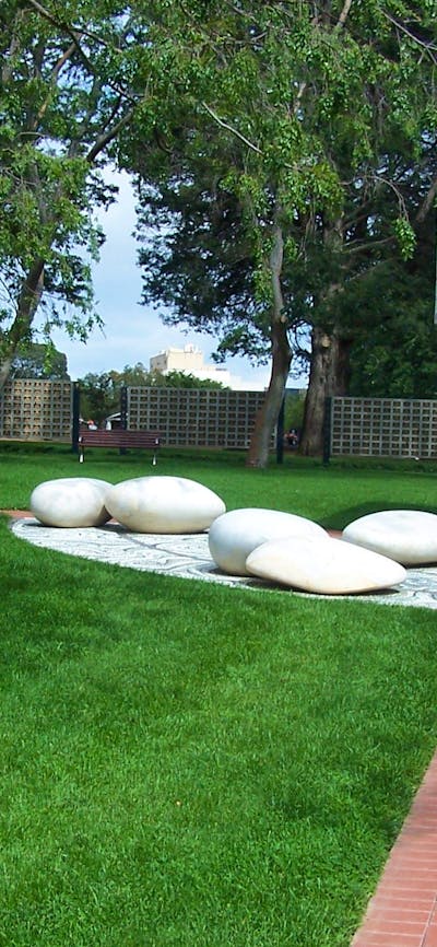 Paved path with mown lawn and ornamental large smooth white stones