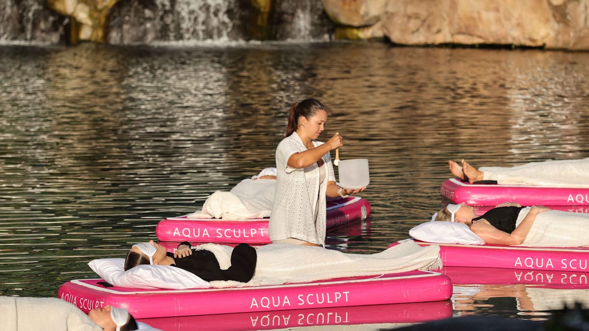 Aqua Sculpt sound bath practitioner creating sound frequencies using crystal sound bowls