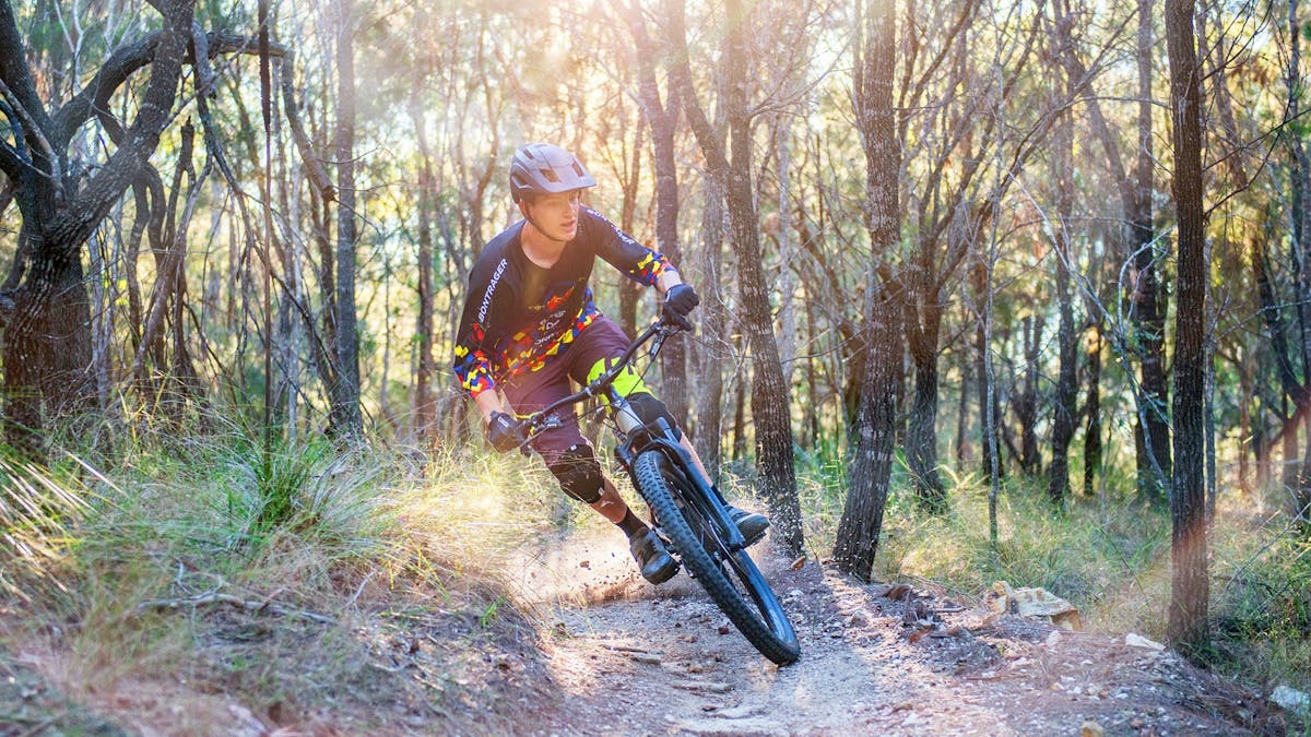 Close-up of cyclist riding through grasslands at Bayview Conservation Area, Redlands Coast