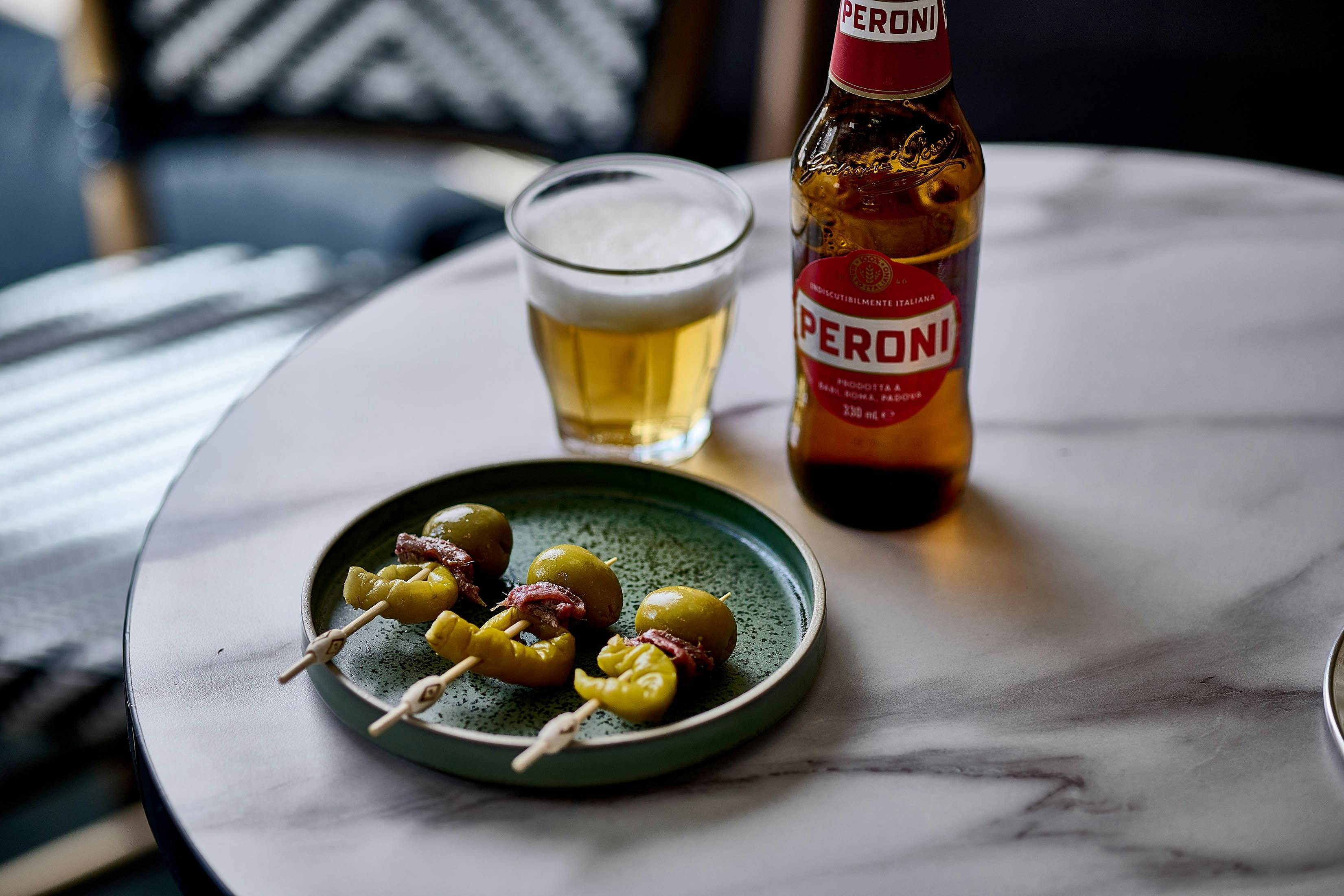 Peroni beer served with 3 Gilda - anchovie, olive and pepper skewers