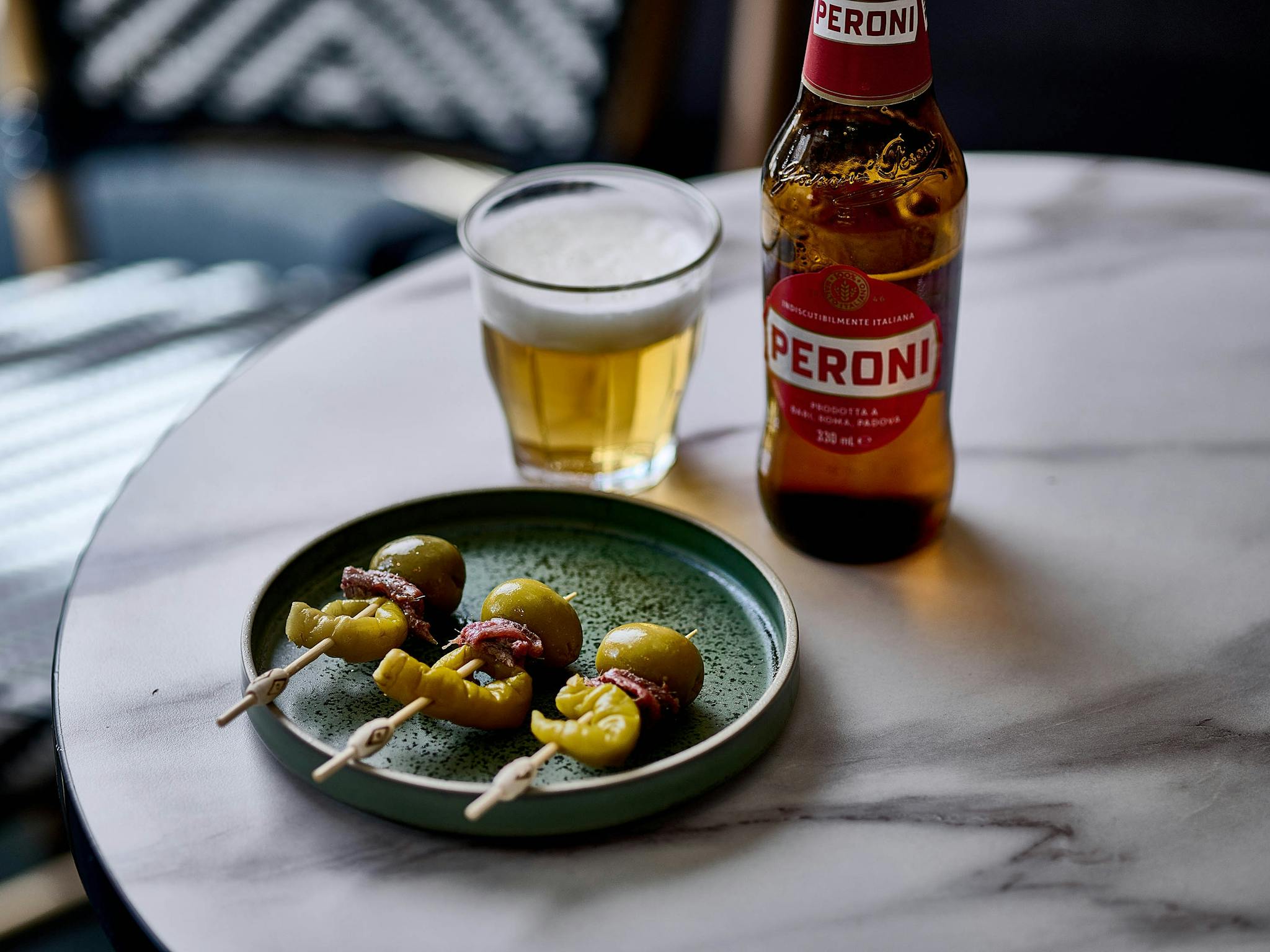 Peroni beer served with 3 Gilda - anchovie, olive and pepper skewers