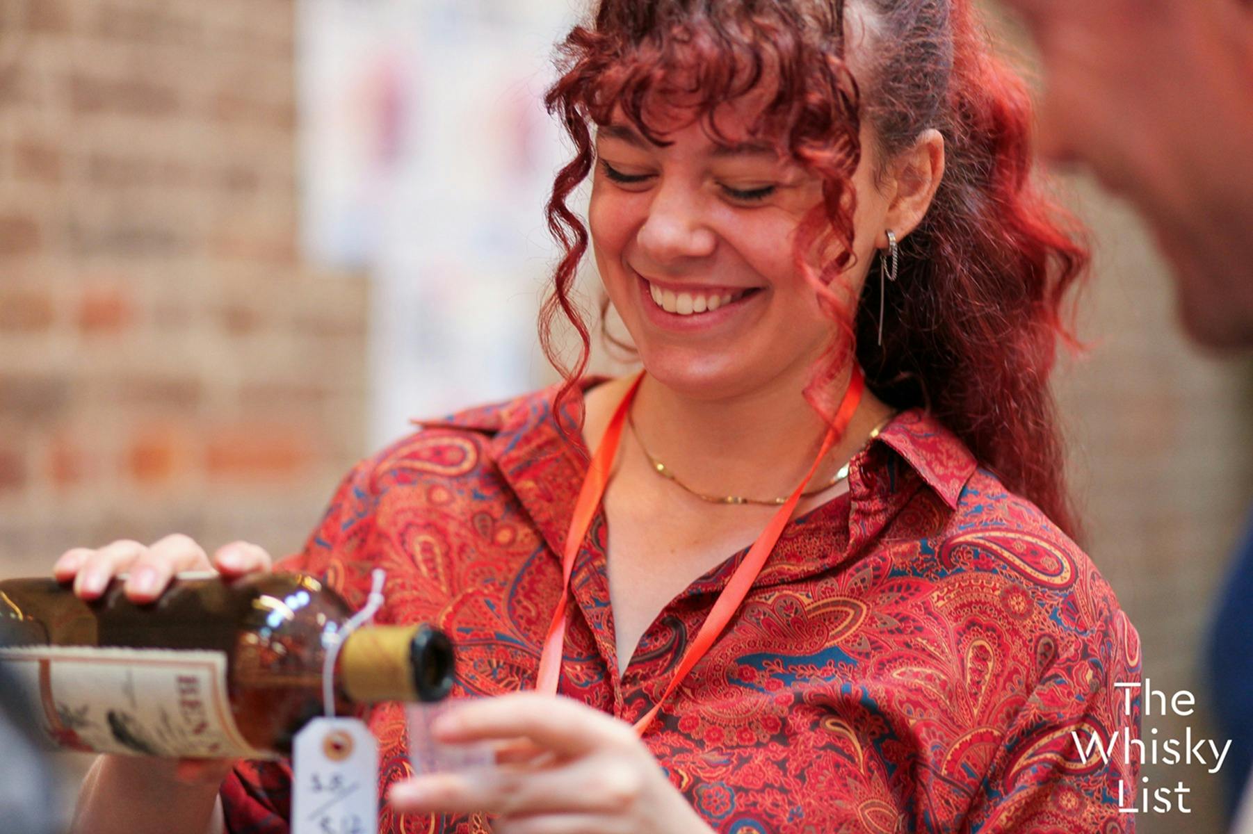A female staff member pours a sample of Ben Nevis Scotch Whisky