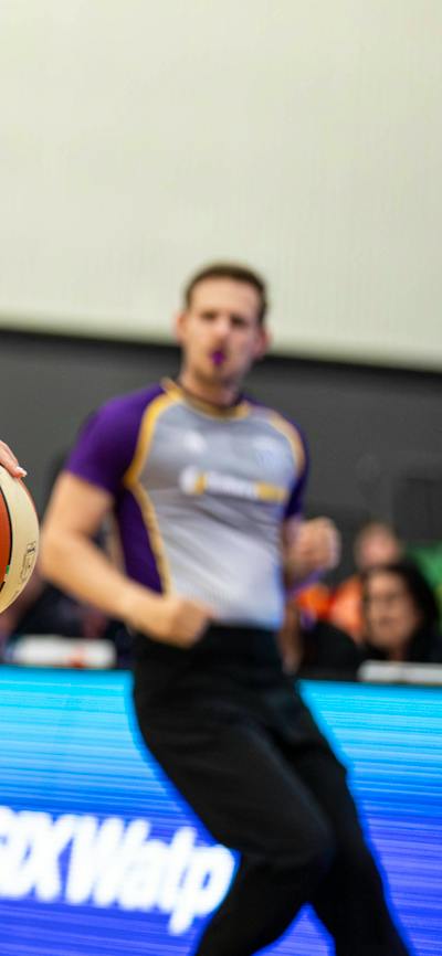 Female basketball player bounces the ball.