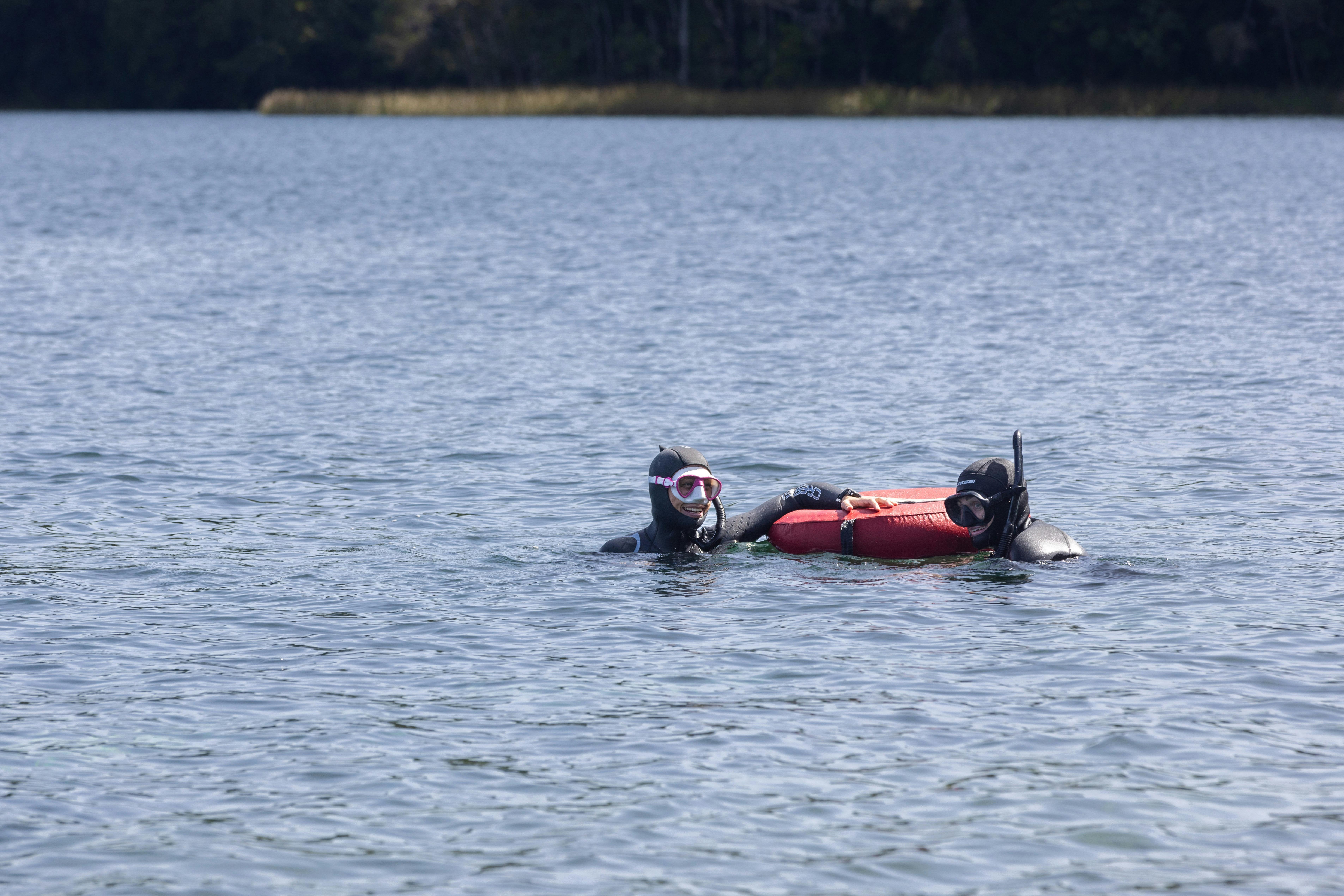 Instructor and student in the water practicing technique surrounded by calm waters of the lake