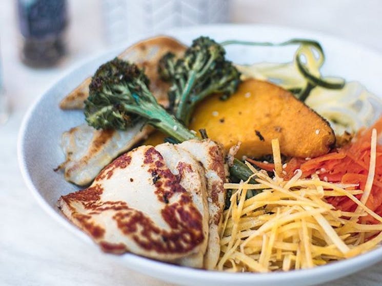A bowl of breakfast foods such as grilled haloumi and broccoli