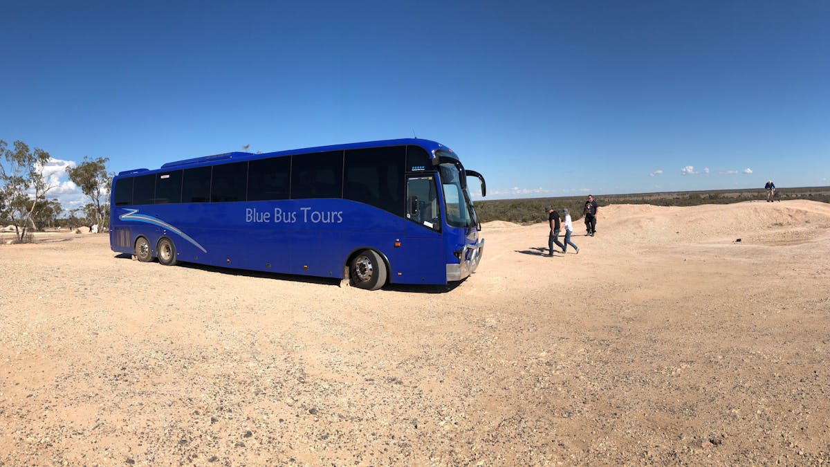 Tour coach and people at lookout at Lightning Ridge