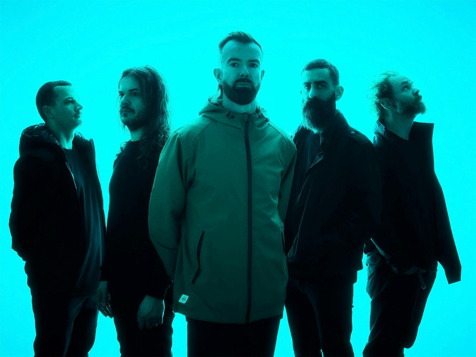The five members of Karnivool in a neone blue background looking different ways off camera.