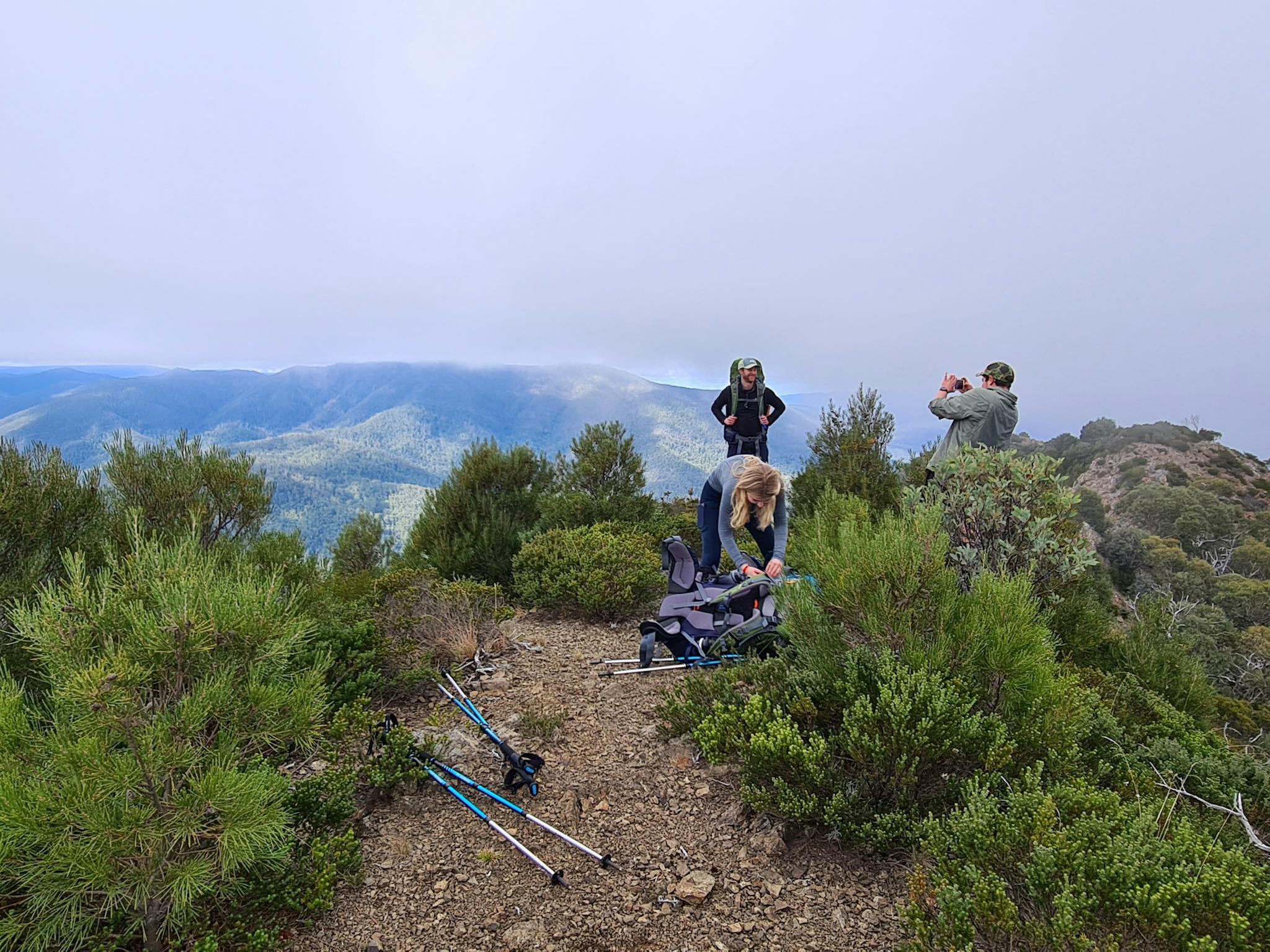A small group of hikers taking photos from the summit.
