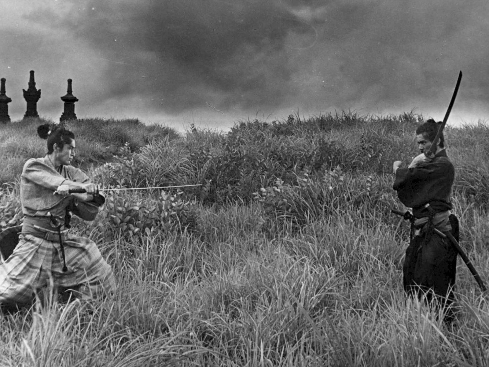 Black and white image in a field with two people wielding swords