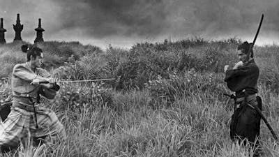 Black and white image in a field with two people wielding swords