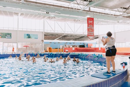 a group of elderly swimmers enjoying an aerobics lesson in the pool