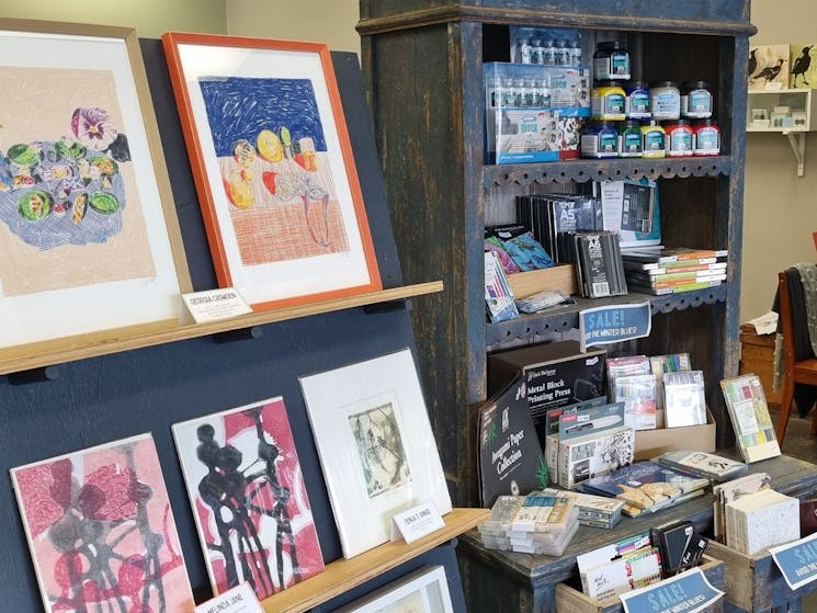 shelves with framed artworks and art materials