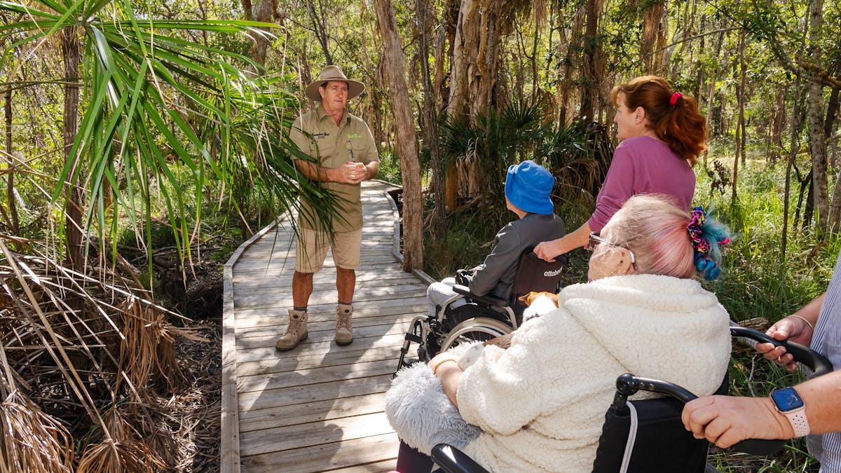 Tourguide explaining native plant use to guests with accessible needs in Agnes Water/1770