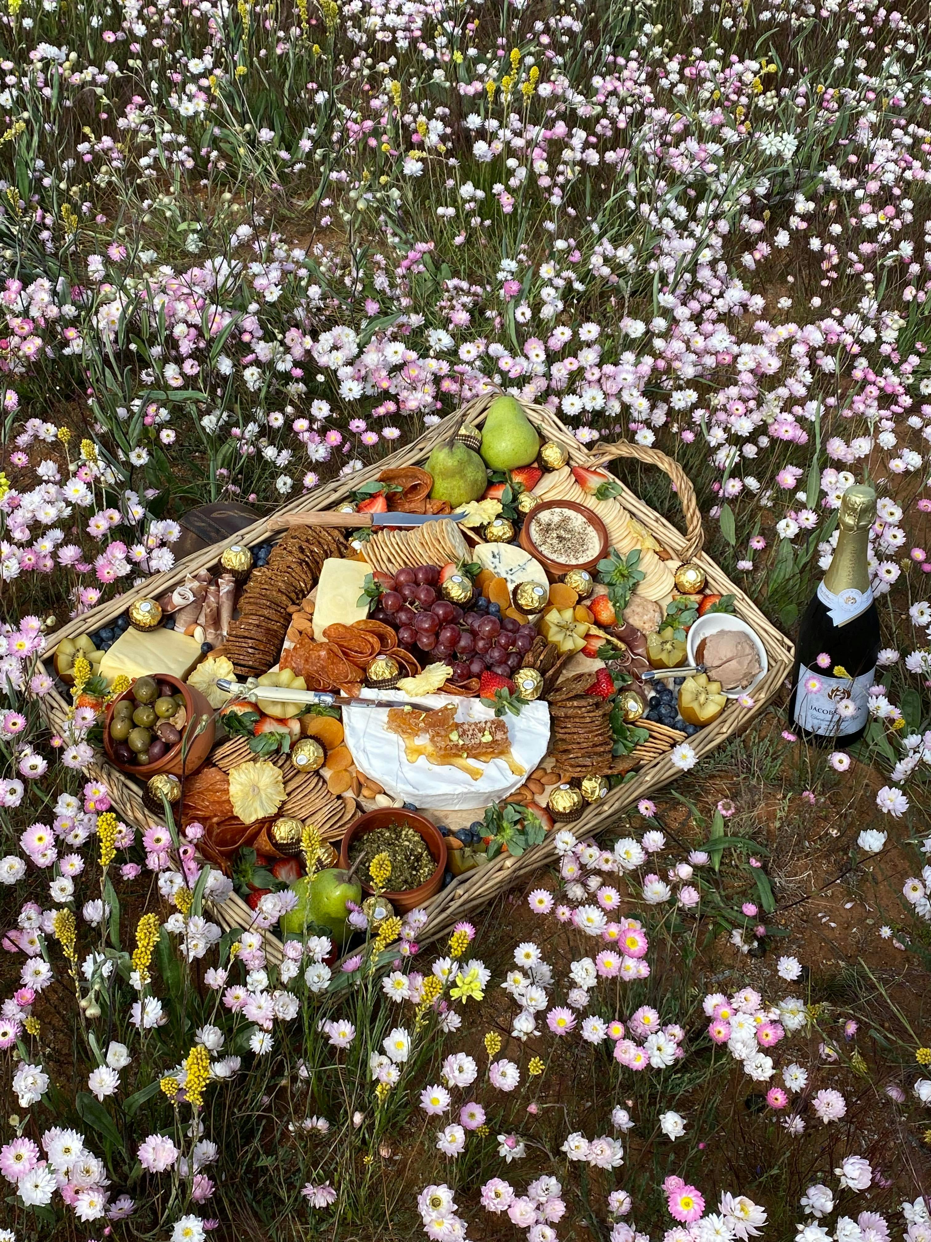 Gormet tasting plate of local produce surrounded by wildflowers enjoyed on Ocean2Outback WA tour