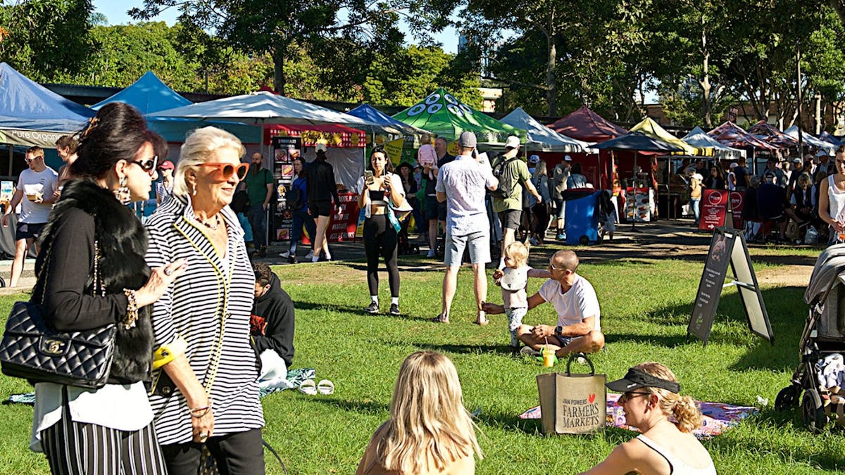 People enjoying the market sitting on the lawn