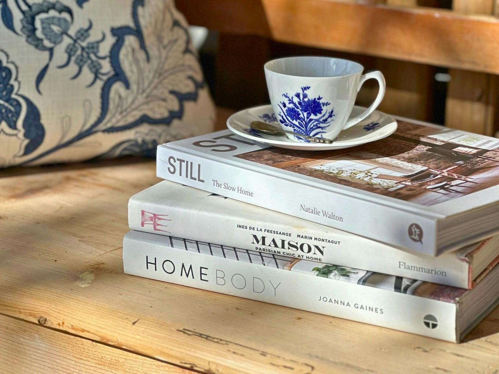 ベンチシートに積み重ねられたインテリアの本と紅茶